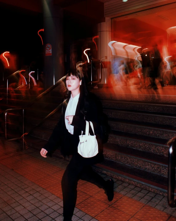 a woman running down a subway platform with a bag