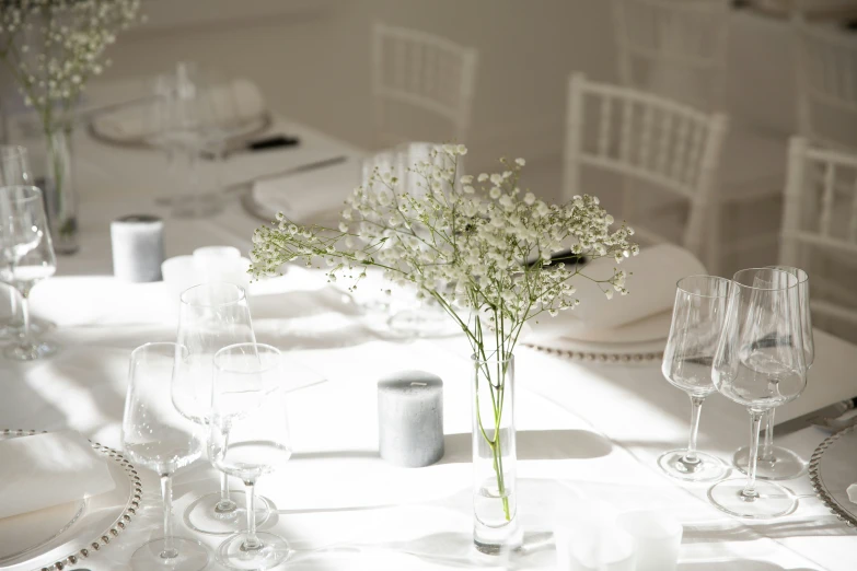 the table is set with white dishes and glasses