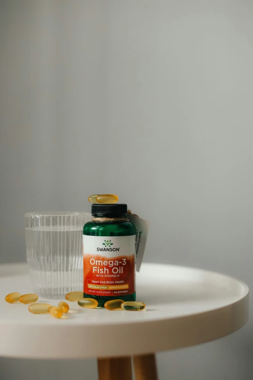 an open medicine bottle and pill sitting on top of a table