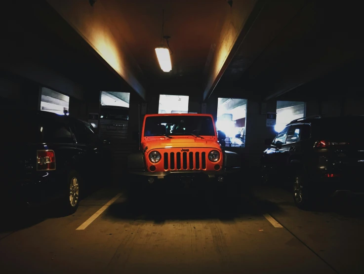 a jeep with light on in an underground car park