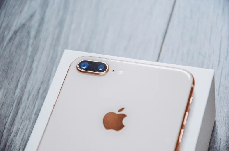 an iphone sits on top of a box on a wooden table