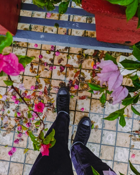 a person in boots standing on tiled walkway