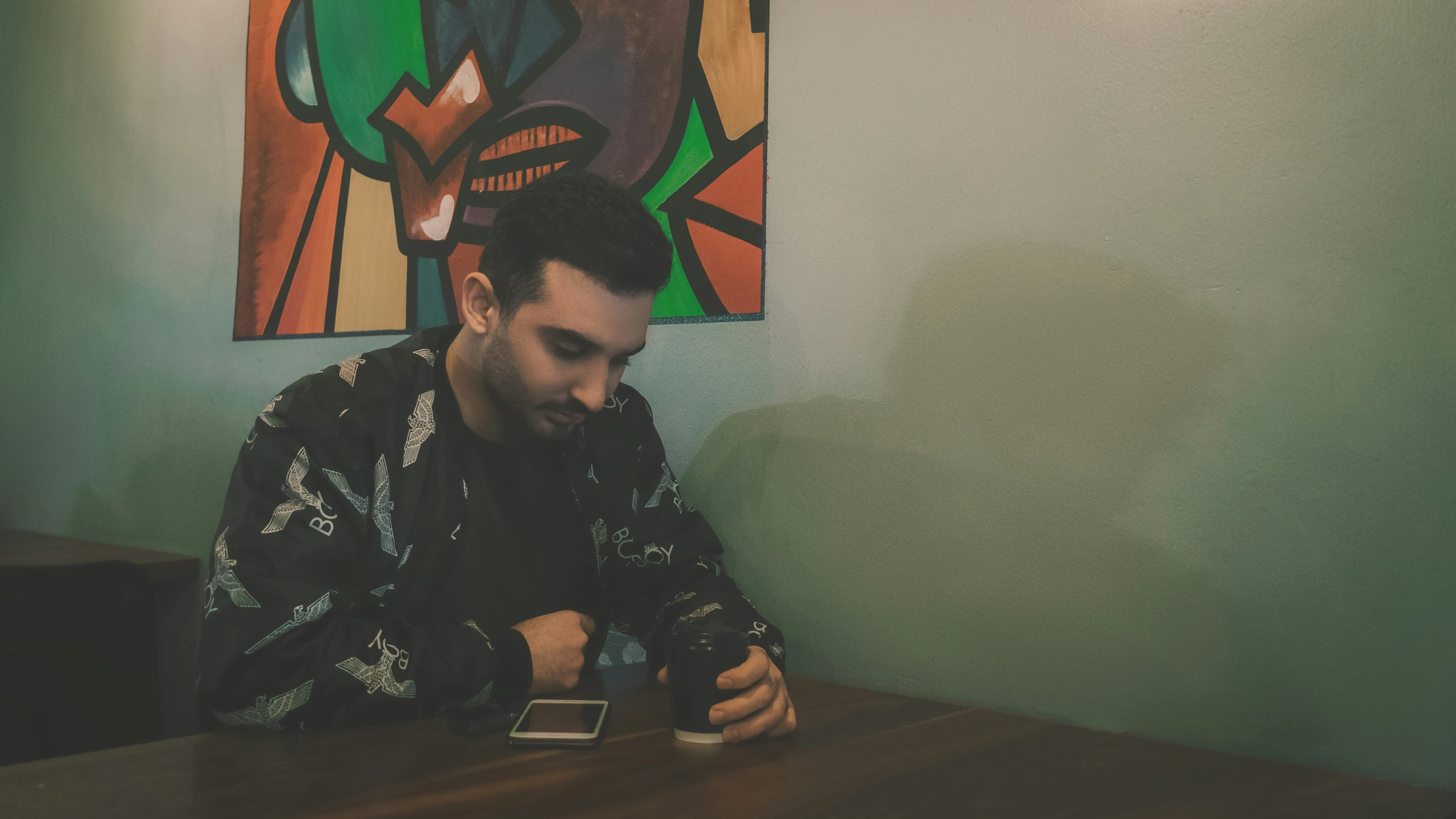 man sitting down in front of his cell phone