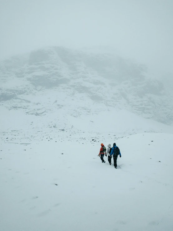 a group of people walking on top of snow covered ground