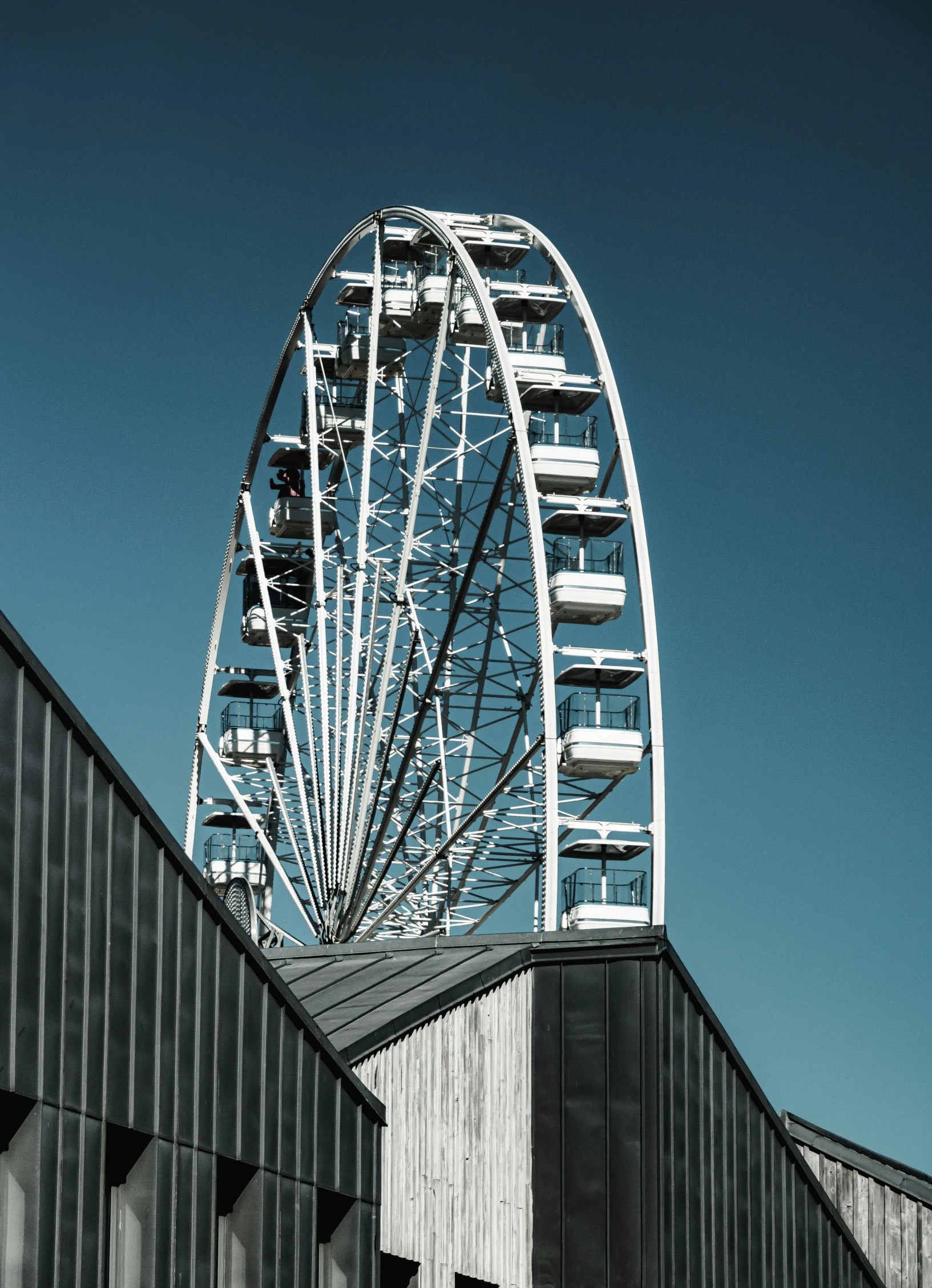 a big ferris wheel and buildings in front of a blue sky