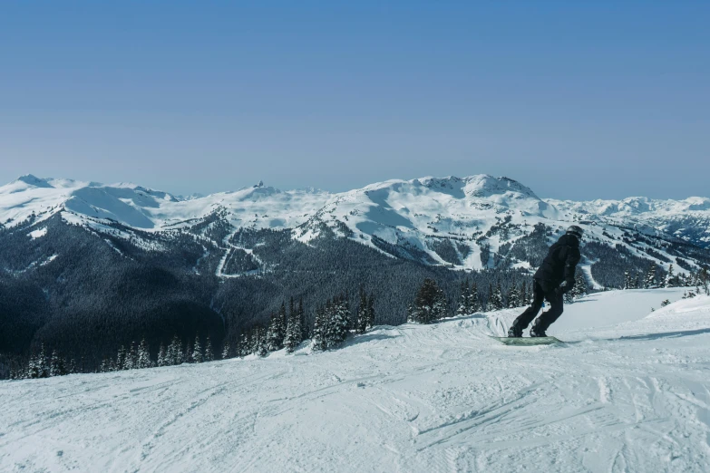 a man riding on top of a snowboard down the side of a ski slope