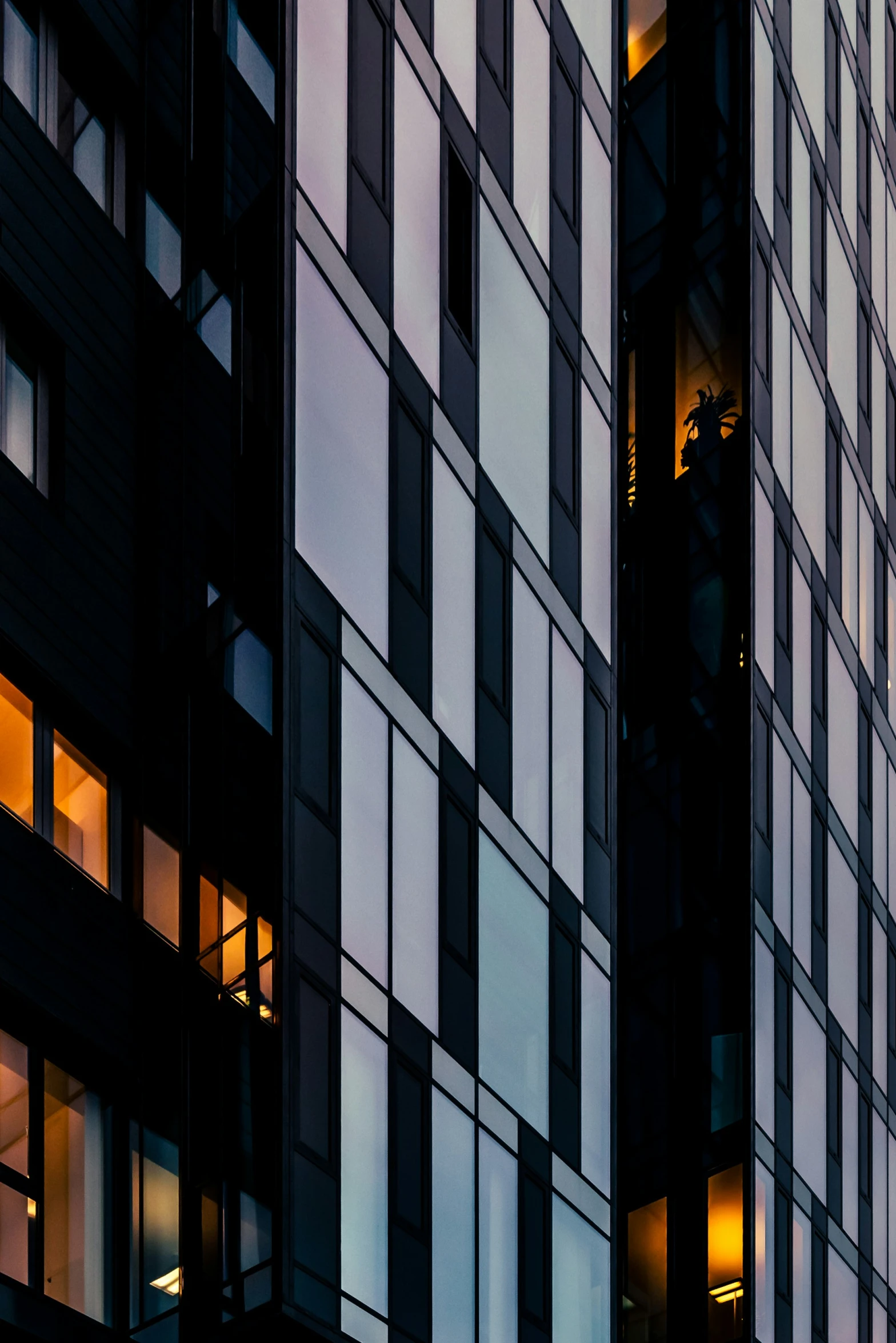 a close up of two windows at night with building lit up