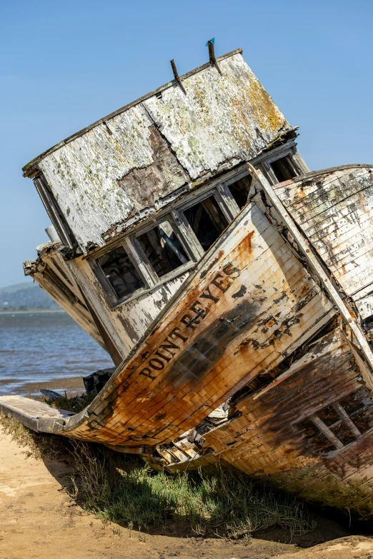 two old boats lie stranded in sand on a beach