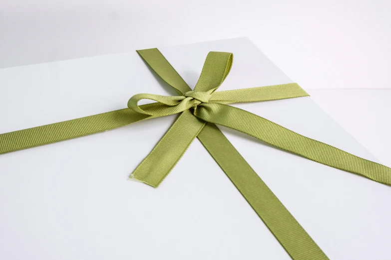 an open green ribbon on a white sheet
