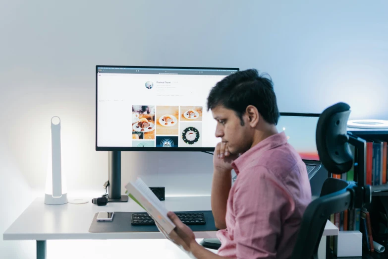 a man sitting in front of a computer monitor