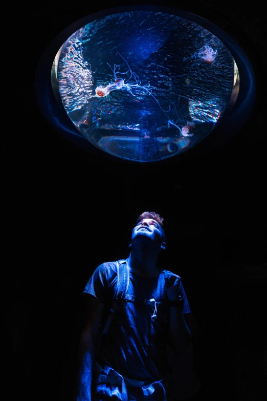 a man in front of a glass dome with a black background