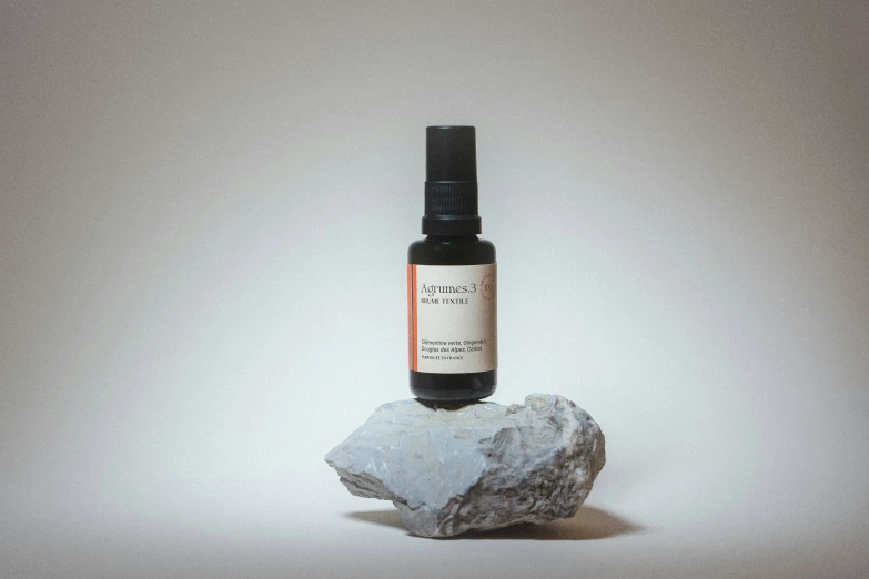 a bottle of cbp sits atop a rock on a gray background