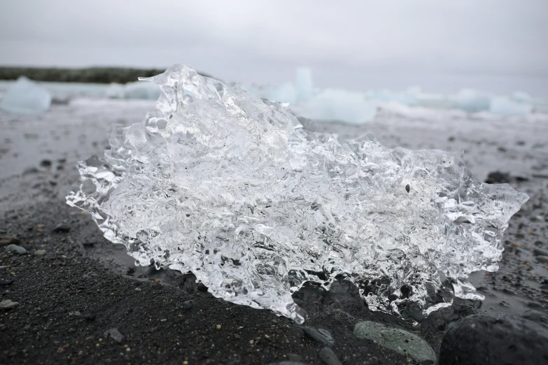 a clear rock next to an ocean