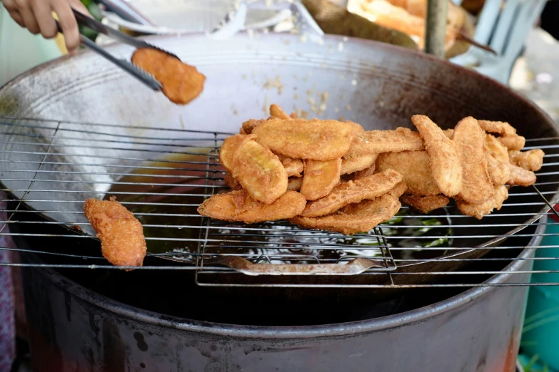 a close - up of fried food on a grill in a pan