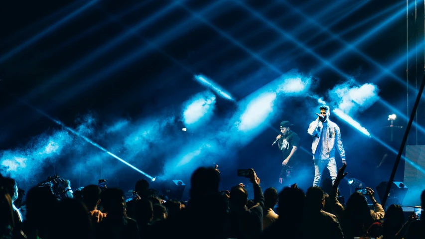 a crowd of people watching two singer on stage