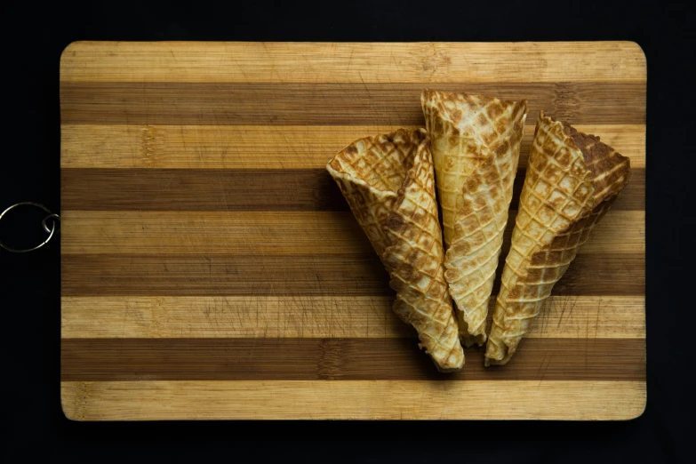 three waffle cones on a wooden  board