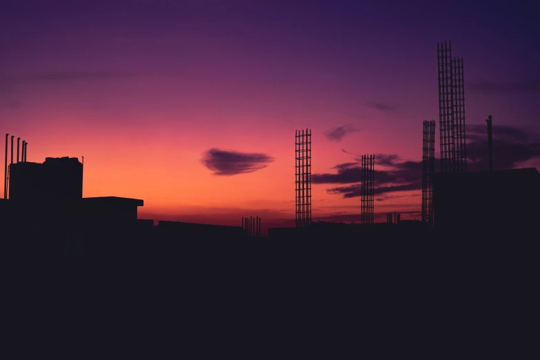 the silhouette of a building against a purple sky