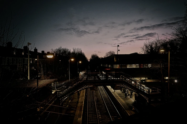 a train track with a building in the background at night