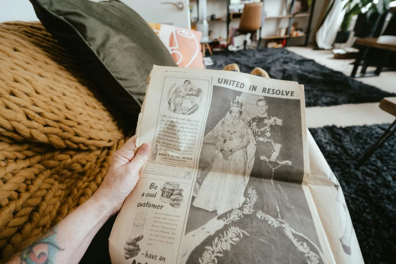 there is a person reading a newspaper in the living room