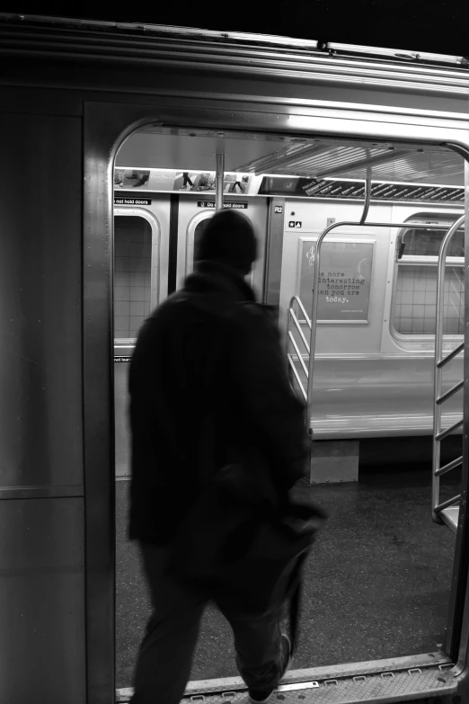 a man exiting a subway train carrying a large bag