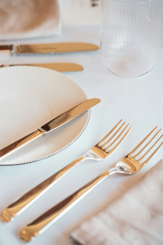 the table with a bunch of golden forks and silverware