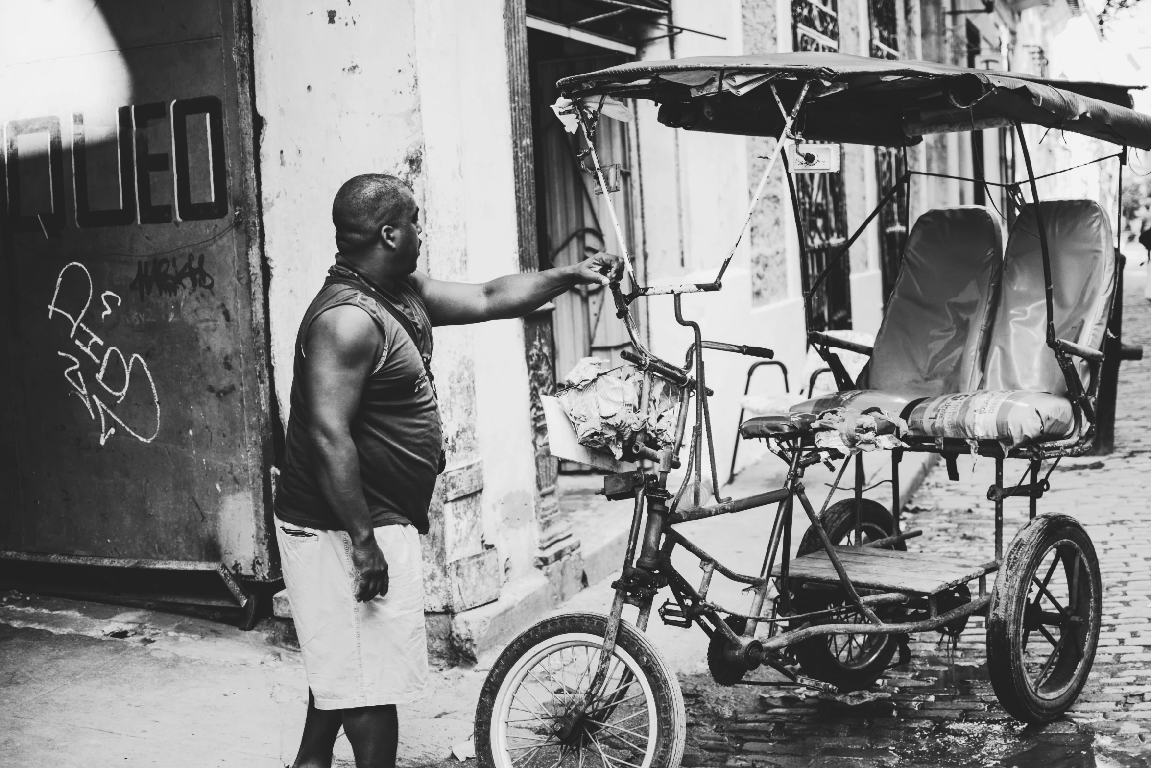 a black and white po of a man standing near a bicycle