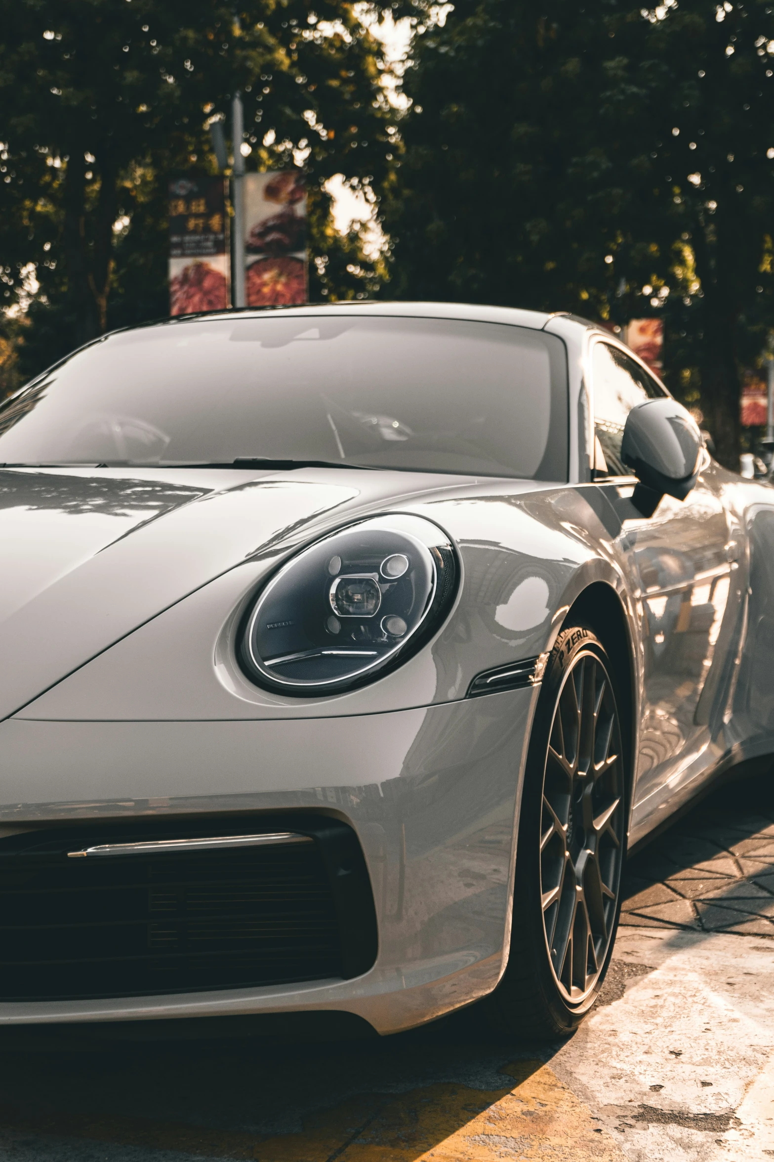 the front of a gray sports car on a street