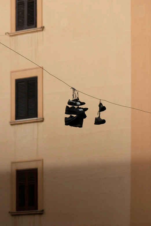 a line with shoes hanging on them in front of a tall building