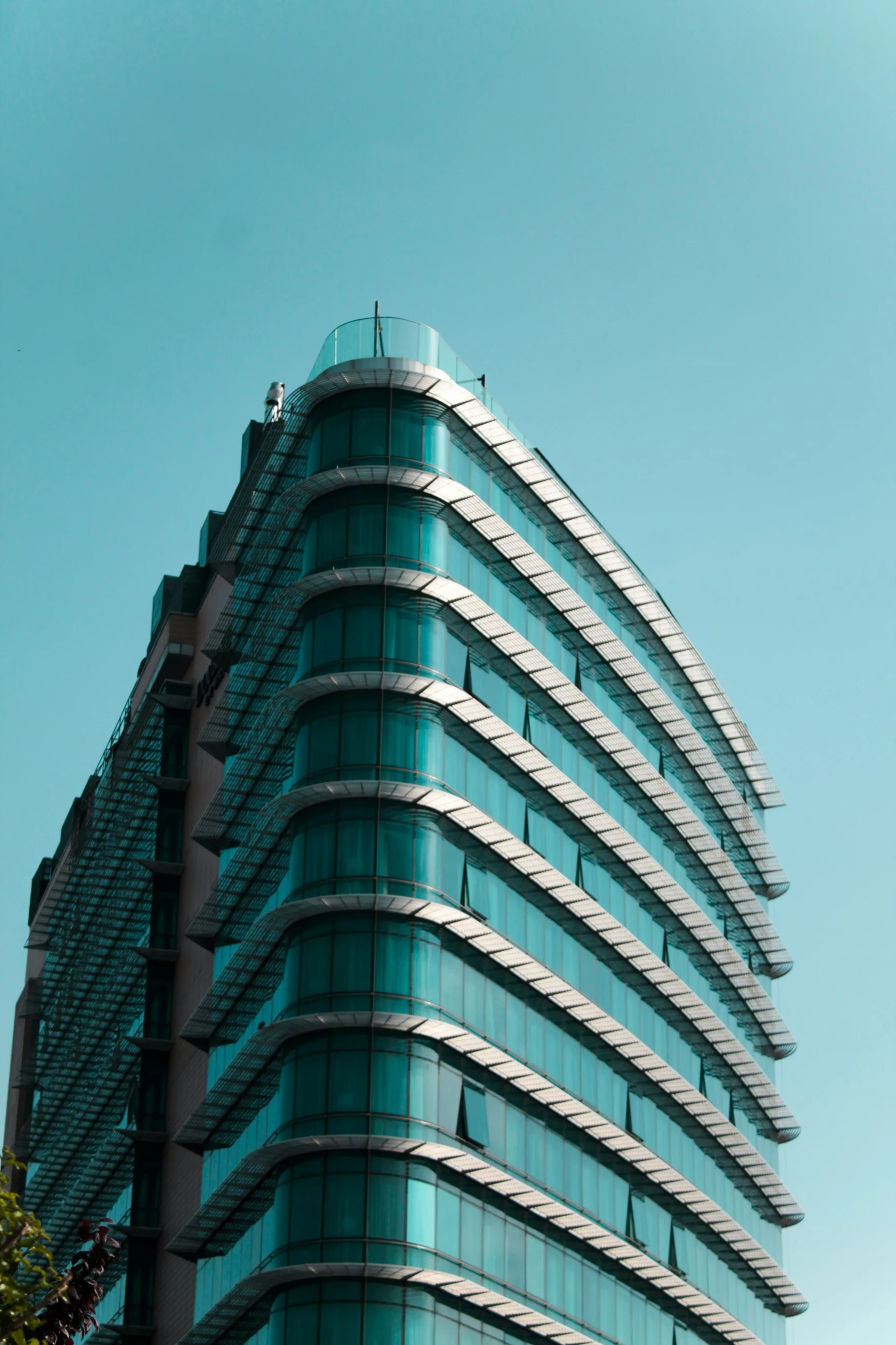 the blue glass building has a sky background