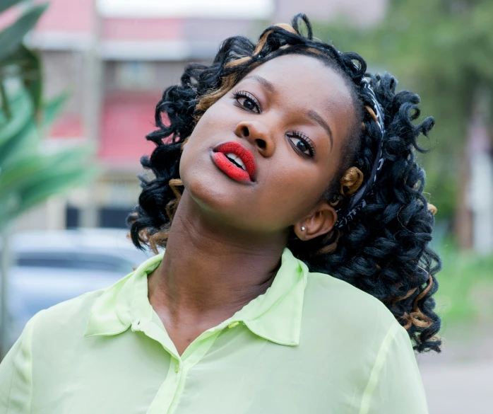 woman wearing green shirt looking up with red lipstick