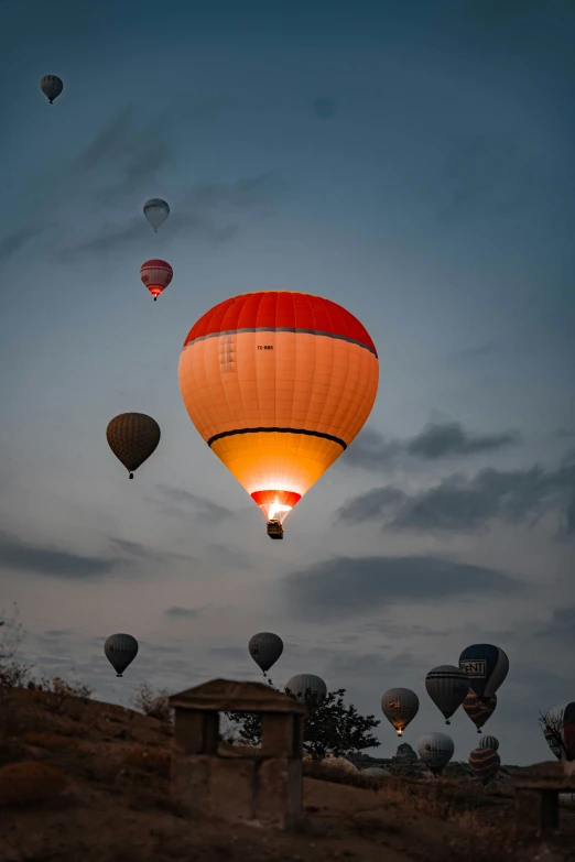 several  air balloons are being inflated in the sky