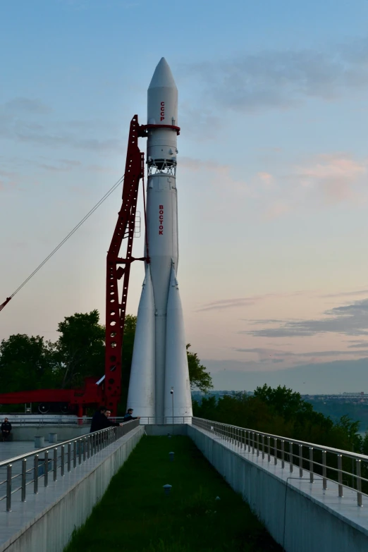 a large rocket like object on display with a crane