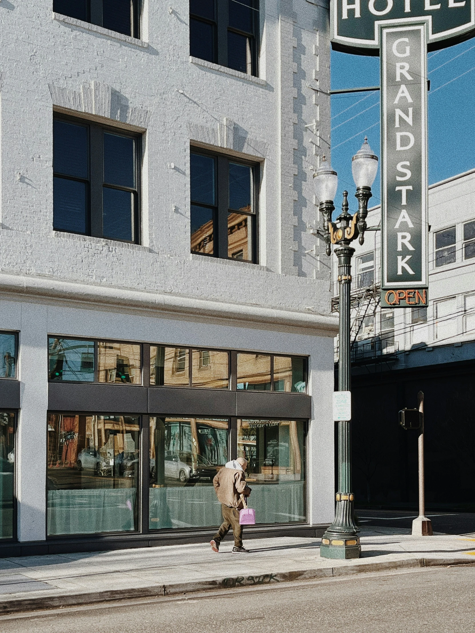 a man and child walking down a street in front of a tall el