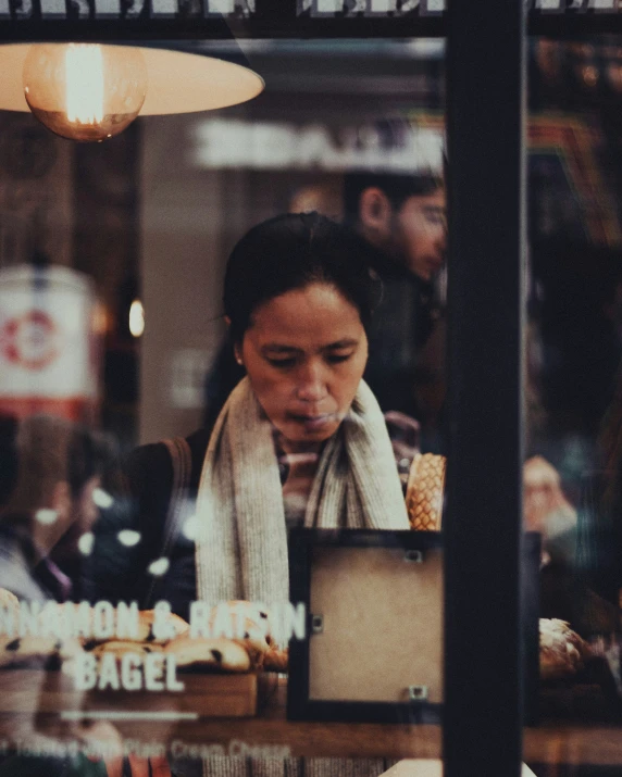 a woman looks down at a laptop outside