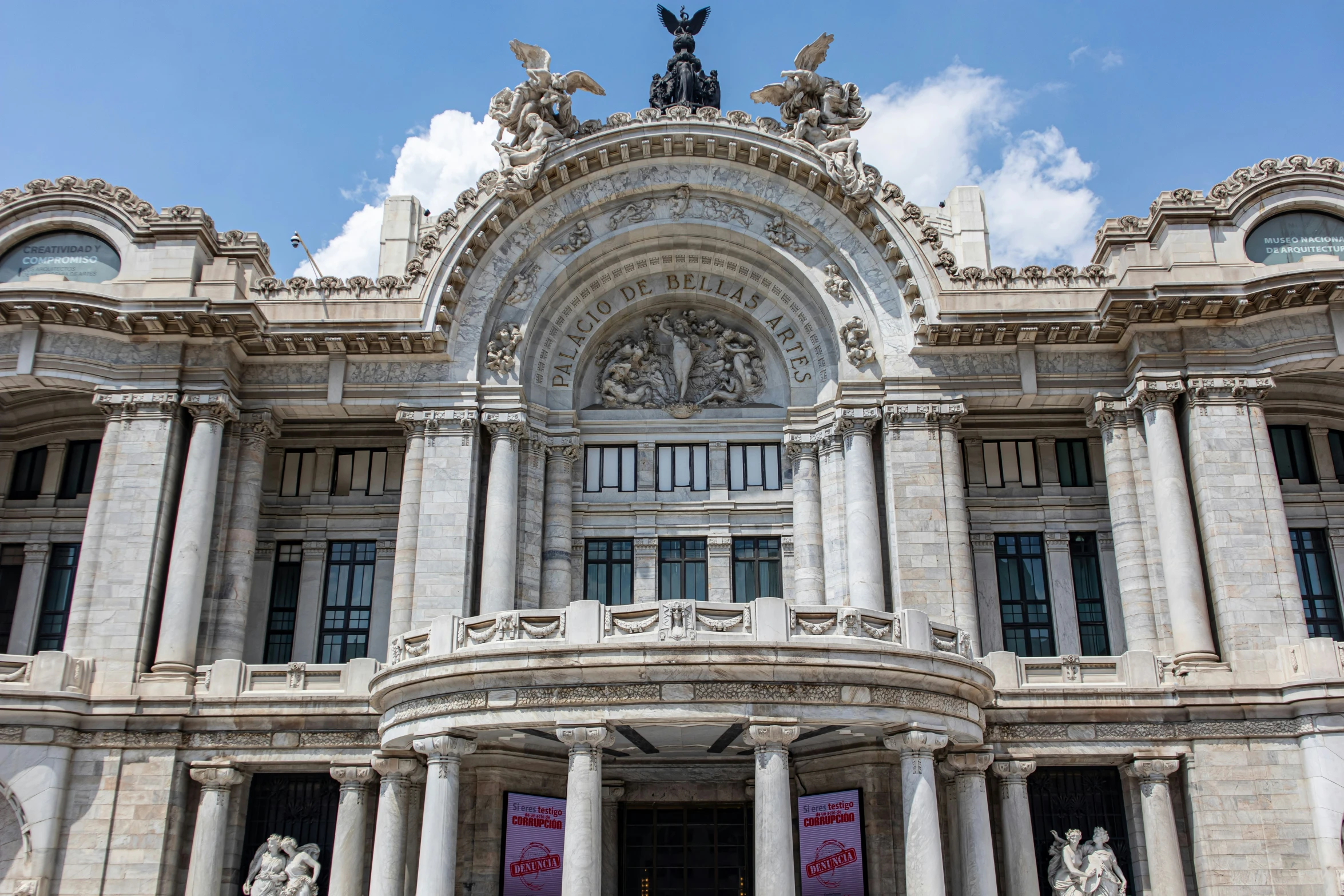 a building with pillars and a statue in front