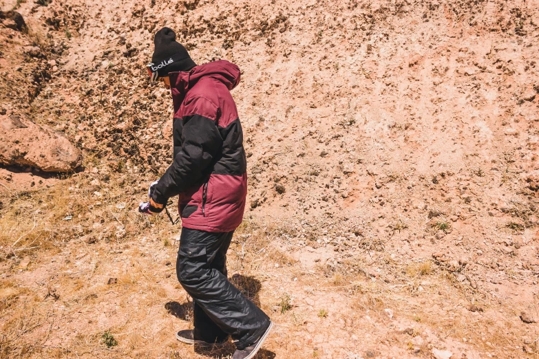 a man is walking in the snow with a snowboard