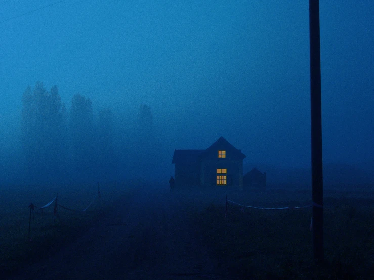 a house in the fog by some trees