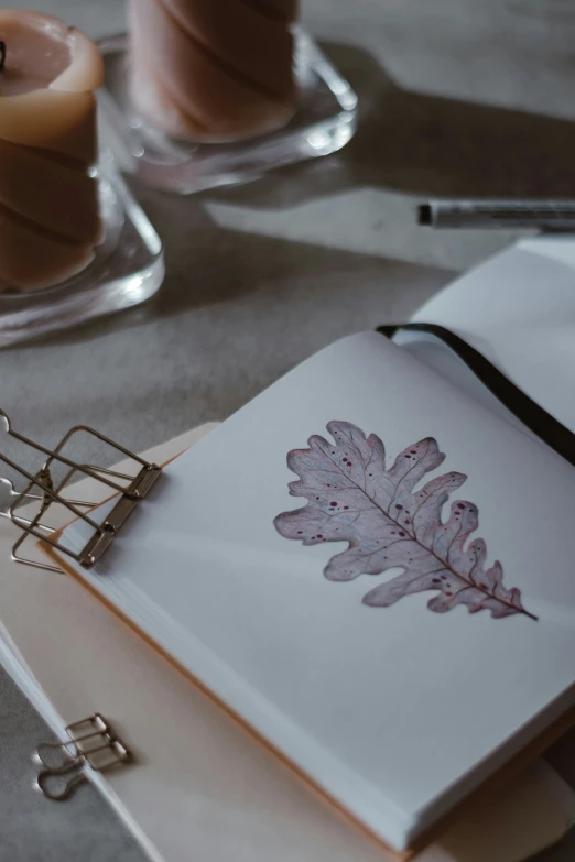 a notebook sitting on top of a table next to some candles