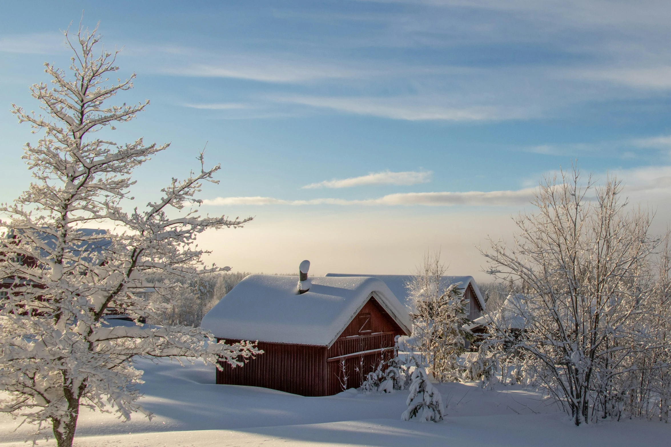 a snow covered cabin is sitting in the mountains