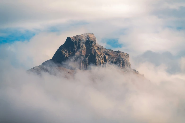 a tall mountain sitting in the middle of some clouds