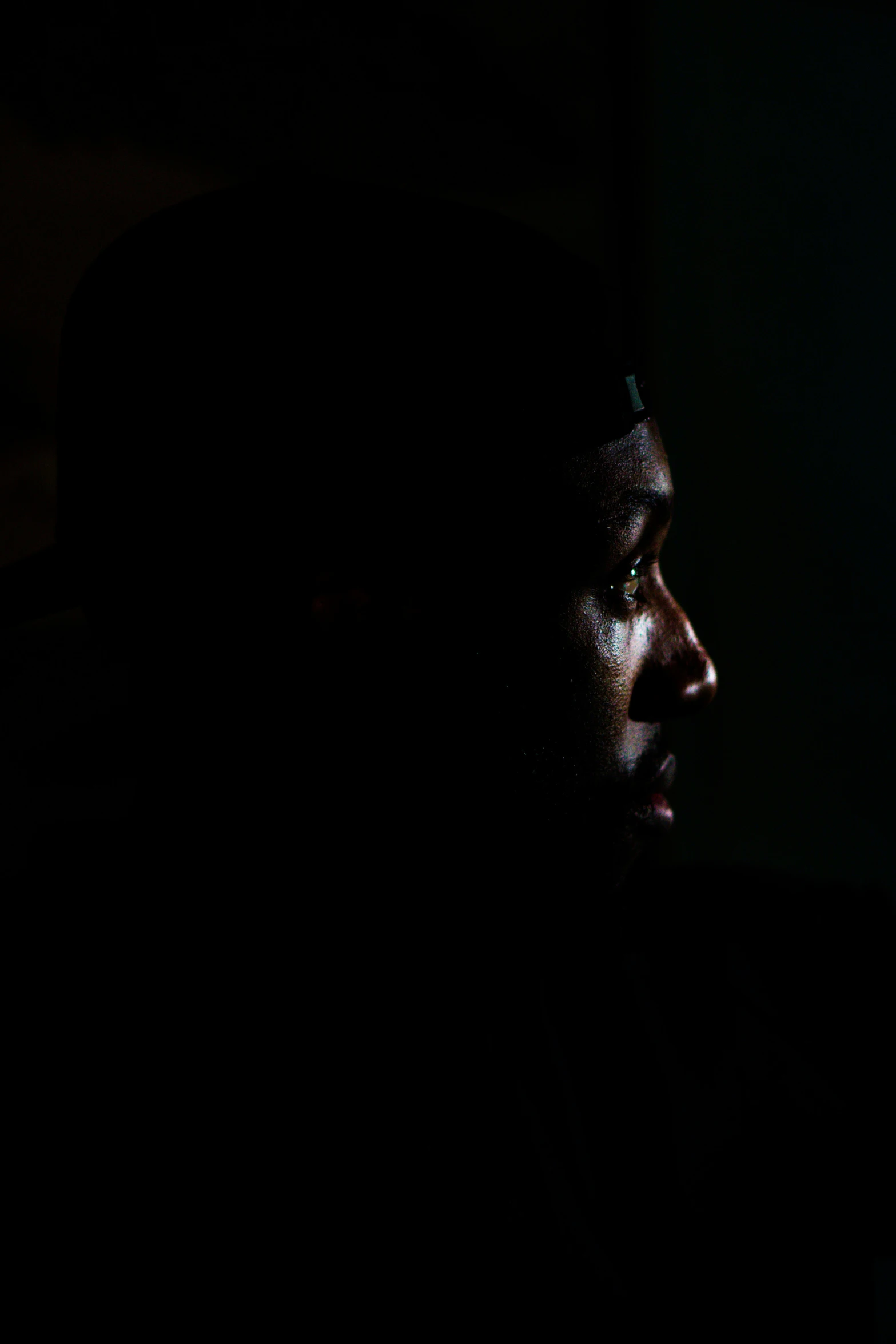 silhouette of man in dark room staring off camera