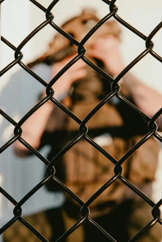 a man taking a picture of himself through a fence