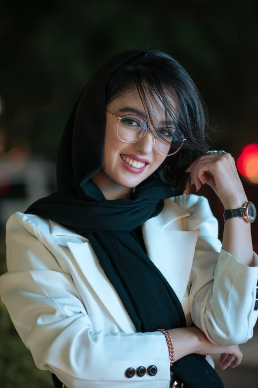 a woman wearing glasses and a white jacket