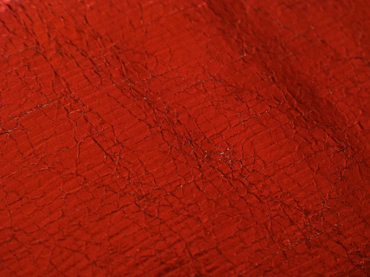 the texture of red cloth with some white and orange designs
