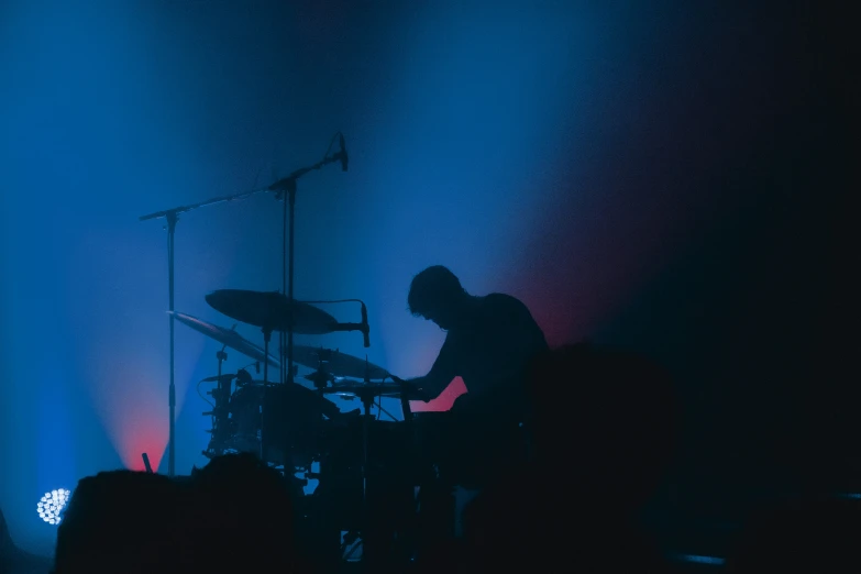 a band playing together in front of a purple and blue stage