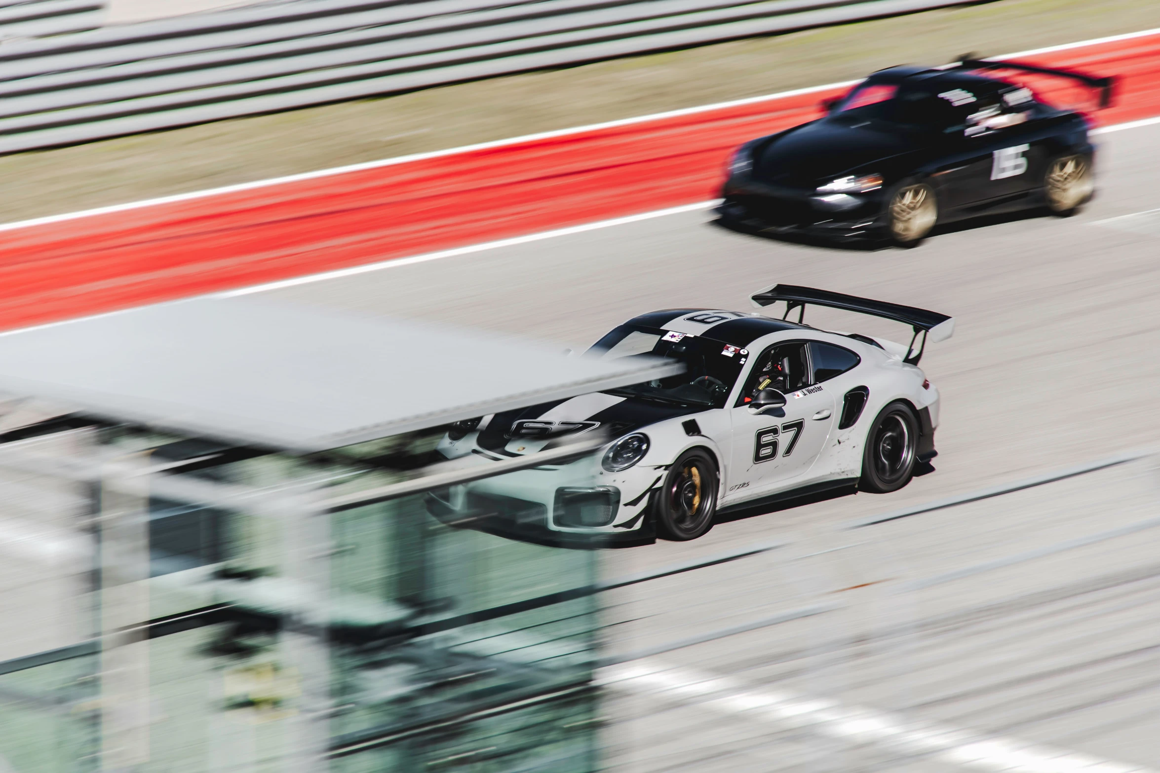 a black car driving down a race track