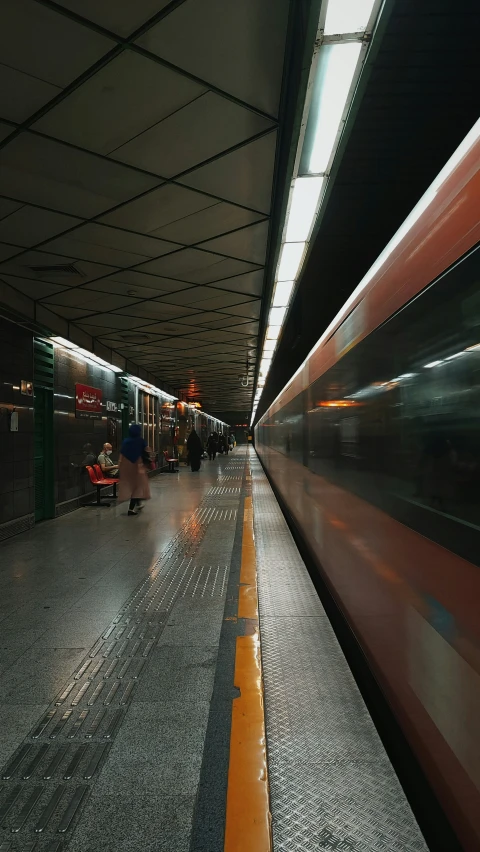 a train passing by with the people waiting for the train