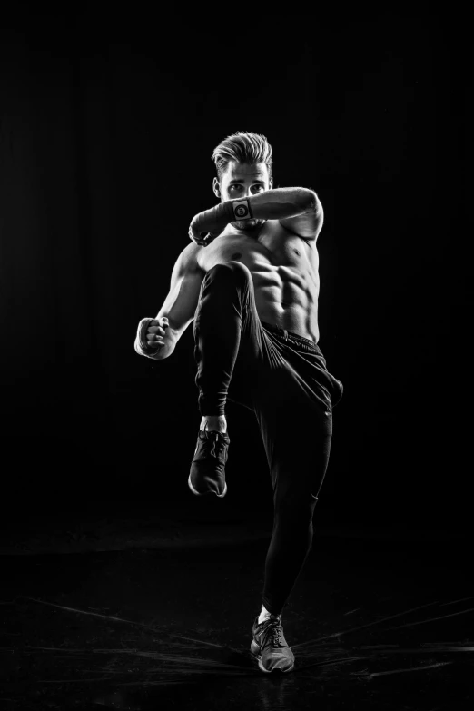 a young man with  on is doing kickbox moves