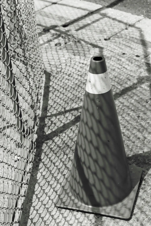 this is an outdoor po of a cone next to a chain link fence