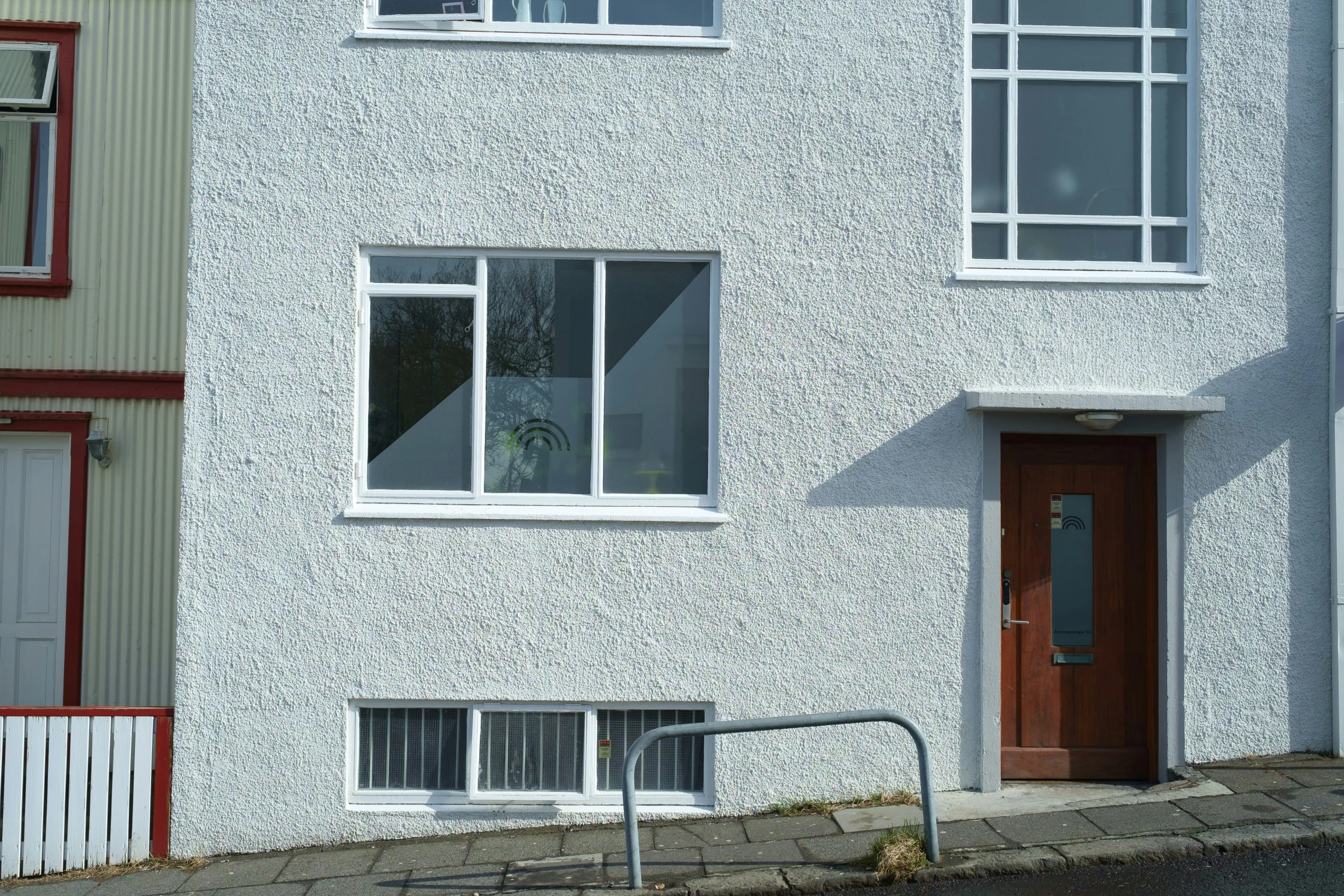 a dog is in the window of a very white building